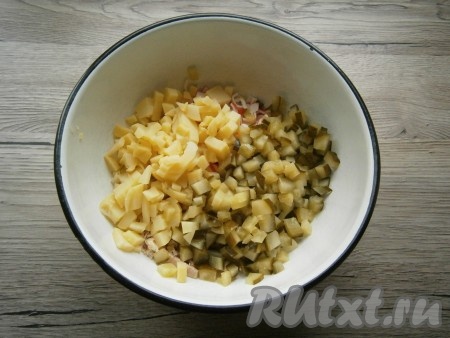 Нарезать маринованный огурец и очищенный картофель маленькими кубиками, добавить в салат из курицы и крабовых палочек.
