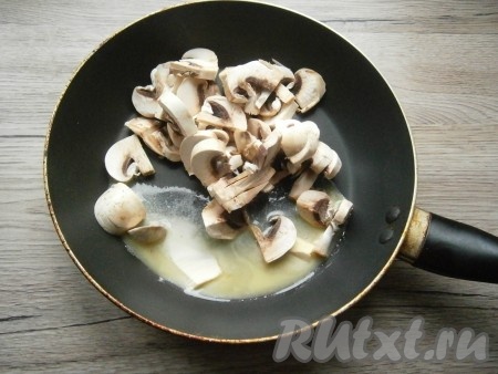 Шампиньоны нарезать пластинами, выложить в сковороду с растопленным сливочным маслом.