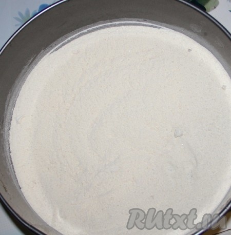 В глубокой миске соединяем муку, сахар, манку, разрыхлитель, тщательно перемешиваем сухие ингредиенты, делим их на две равные части. Разъёмную форму для выпечки диаметром 22-24 сантиметра смазываем растительным маслом, высыпаем одну часть сухих ингредиентов, разравниваем.