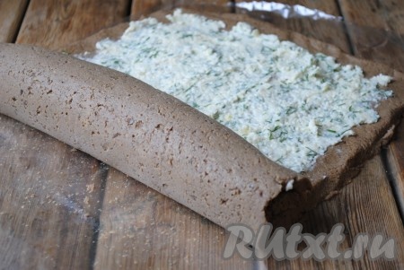 Аккуратно с помощью плёнки свернуть печеночный рулет, чтобы начинка из сыра и чеснока оказалась внутри. 
