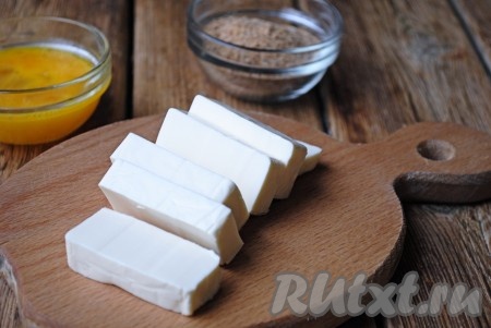 Панировочные сухари насыпать в отдельную миску. Плавленный сыр разрезать на длинные полосы шириной 0,5-1 см.