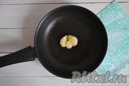 В разогретую сковороду влить растительное масло. Крупный зубчик чеснока очистить, раздавить тыльной частью ножа и выложить в разогретое масло. Обжарить чеснок в течение 30 секунд с обеих сторон и убрать со сковороды.
