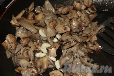 Предварительно отварить в подсоленной воде очищенный картофель до полуготовности. Грибы обжарить на растительном масле до испарения жидкости, примерно минут 7, посолить и поперчить. Добавить нарезанный пластинками чеснок.
