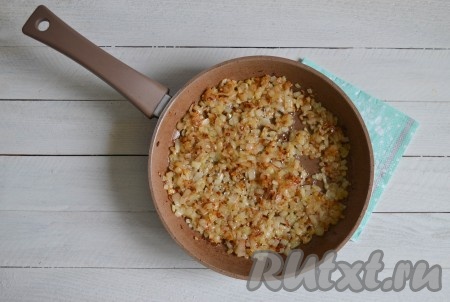 На сковороду, в которой готовились шкварки, выложить очищенный лук, нарезанный мелкими кубиками. Помешивая, обжарить лук на среднем огне до золотистости (в течение 5-7 минут). Половину лука выложить к шкваркам.
