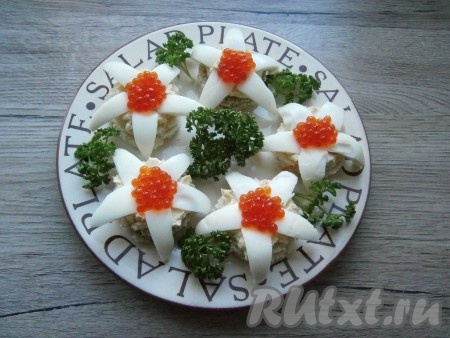 В центр "цветочков" выложить по 1 чайной ложке красной икры. Украсить бутерброды зеленью.
