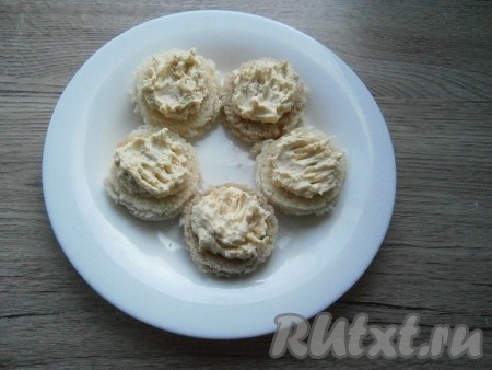 Намазать подготовленной массой из масла и желтков кружочки хлеба.