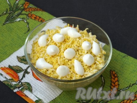 Затем очистить, натереть на тёрке яйца и выложить их поверх кукурузы, смазать майонезом.
