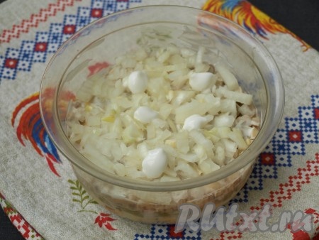 Очистить репчатый лук, нарезать мелкими кубиками, выложить на шампиньоны и смазать майонезом.
