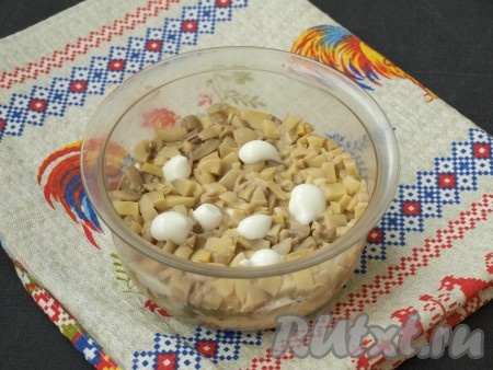 Измельчить шампиньоны и выложить их следующим слоем, также нанести майонез.
