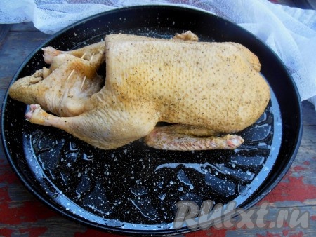 Смажьте противень растительным маслом, выложите утку на противень спинкой вниз. Для того чтобы блюдо получилось более ароматным, колечки лимона можно оставить в брюшке. При необходимости, скрепите брюшко зубочистками.
