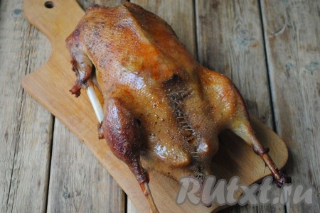 Птицу достать из духовки, вынуть из пакета для запекания, удалить нитку, которой зашивали брюшко, и можно подавать на стол.
