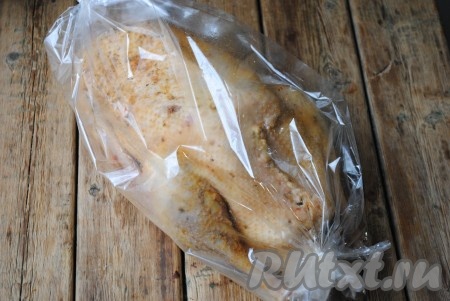 Гуся, фаршированного апельсинами, поместить в рукав для запекания, завязать рукав с двух сторон. Гуся в рукаве выложить на противень и отправить в духовку, разогретую до 180 градусов. Запекать 1,5-2 часа (время запекания зависит от размера и возраста птицы, а также от духовки). За 5 минут до готовности достать гуся из духовки, разрезать аккуратно рукав, смазать поверхность птички медом и полить вытопившимся жиром. Благодаря мёду и жиру, гусь получится с аппетитной румяной корочкой.
