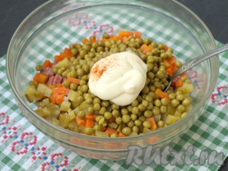 Сложить картофель, яйца, колбасу, морковь и огурцы в миску, добавить консервированный горошек. Салат посолить и поперчить, смешать с майонезом.
