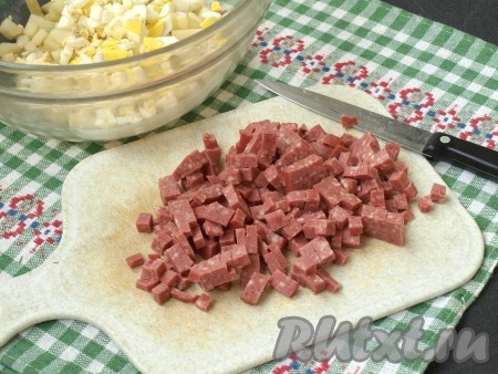 Полукопчёную колбасу освободить от плёнки и нарезать кубиками.