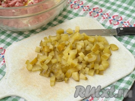 Нарезать кубиками маринованные огурцы.