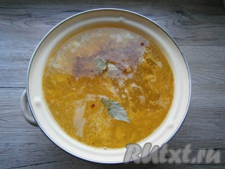 Размятый картофель вернуть в кастрюлю и добавить обжаренные овощи. Всыпать в суп специи, добавить лавровые листья и измельченный чеснок.
