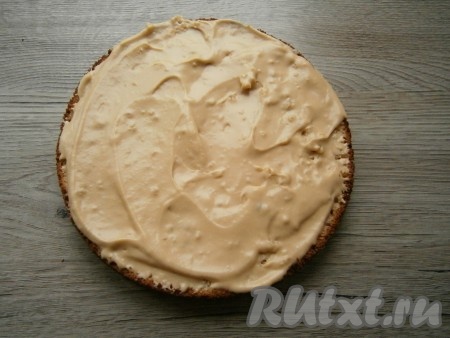 Нижнюю часть бисквита щедро смазать масляным кремом.
