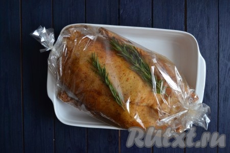 Выложить гуся, фаршированного яблоками, в рукав для запекания, затем рукав с обеих сторон туго завязать.
