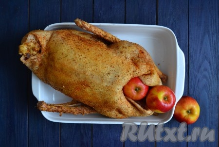 Вымыть яблоки и, если они небольшого размера, выложить их в брюшко гуся. А если всё же используете большие яблоки, тогда их лучше нарезать кусочками среднего размера (сердцевину яблок выбросить) и нафаршировать ими птицу.
