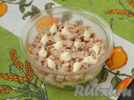 Кубиками нарезать копчёную курицу и выложить её следующим слоем. Снова смазать майонезом.