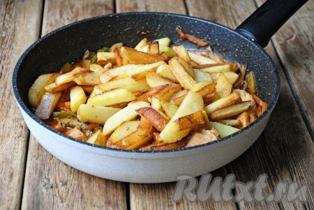 Пока готовится мясо, на отдельной сковороде нужно пожарить картофель, для этого на сильном огне разогреть 2-3 столовые ложки растительного масла, выложить картошку и жарить, иногда перемешивая, до золотистого цвета. Когда картофель будет готов, его нужно посолить. Когда мясо протушится 15-20 минут, выложить в сковороду жареную картошку и тушить под крышкой на небольшом огне еще 10-15 минут.