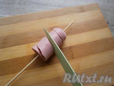 Каждую часть сосиски надеть на шпажку и острым ножом разрезать по спирали, поворачивая шпажку.
