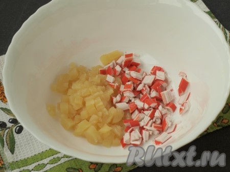 Нарезать кубиками консервированные ананасы и крабовые палочки.

