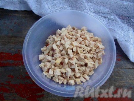 Куриную грудку отварите в подсоленной воде до готовности (в течение 25-30 минут). Охладите, нарежьте на кубики и выложите к моркови.
