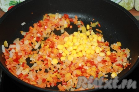 К обжаренным овощам добавить консервированную кукурузу, перемешать.
