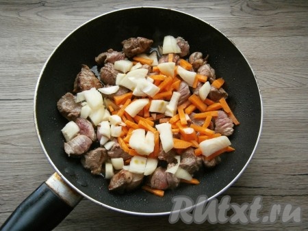 Обжарить кусочки говядины на растительном масле на среднем огне до легкой румяности со всех сторон, затем добавить не крупно нарезанные репчатый лук и морковь, влить соевый соус.

