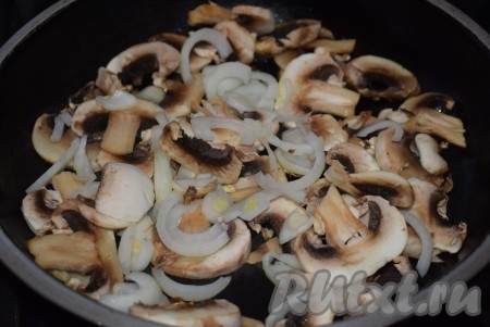 Очищенный лук нарезаем полукольцами. На растительном масле на среднем огне обжариваем лук, помешивая, до прозрачности. Затем добавляем к луку нарезанные шампиньоны, жарим до готовности грибов на среднем огне (минут 10-12), иногда перемешивая.