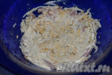 На куриное мясо выкладываем часть натёртых яиц, можно немного присолить, смазываем майонезом, слегка прижимаем ложкой (или лопаткой).