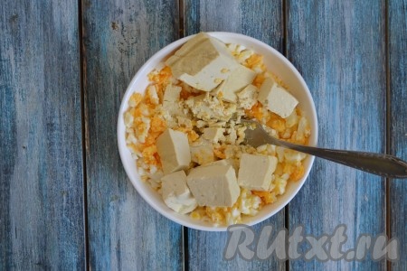 К измельченным яйцам добавить сыр фета и также растолочь вилкой (если вы готовите с сыром твёрдых сортов, то натрите его на тёрке).
