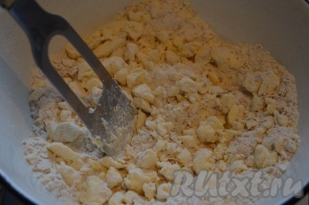 Добавить в миску сахар, соль и охлажденное сливочное масло, порубить всё в крошку. Добавить сметану, всё перемешать. Тесто для творожно-овсяного пирога получится комочками.
