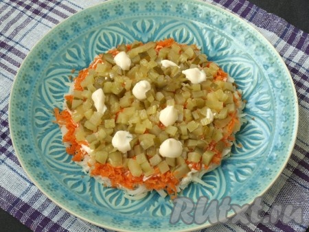 Кубиками нарезать маринованный огурец, выложить третьим слоем, нанести майонез.