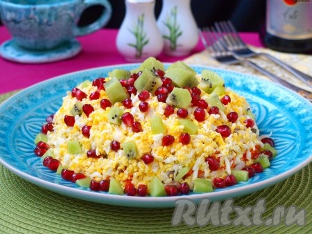 Нарезать кубиками киви. Необязательно нарезать кубиками одинакового размера. Для украшения верха салата я нарезала киви более крупно. Разобрать на зёрнышки гранат. Украсить поверхность салата киви и зернышками граната в произвольном порядке. Вкуснейший салат "Уральские самоцветы" подать к праздничному столу.