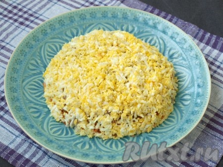 Яйца измельчить на мелкой тёрке и полностью посыпать ими салат.