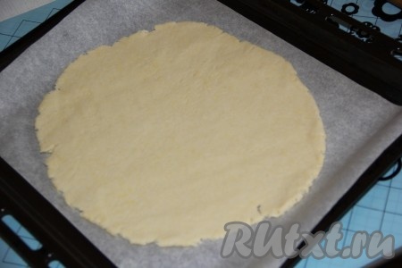 Готовое тесто разделить на 2 части. Противень для запекания застелить пергаментом. На столе, присыпанном мукой, раскатать одну часть теста скалкой, размер раскатанного теста - чуть больше курицы. Выложить тесто на противень.
