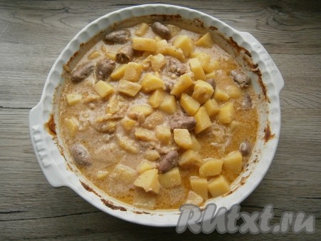 Форму с картошкой и куриными сердечками, накрыв фольгой, отправить в разогретую до 200 градусов духовку на 20 минут. Далее уменьшить температуру до 180 градусов и готовить блюдо под фольгой еще минут 40. Затем фольгу убрать, все перемешать и запекать картофель с сердечками при той же температуре еще 10-15 минут.