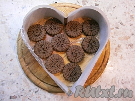 Бока формы внутри проложить полосками пергамента (как на фото), которые равны ее высоте. На дно выложить половину печенья.
