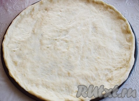 Разделяем тесто на 2 части (из этого количества у меня получается 2 больших пиццы диаметром 34 см). Из одной части я приготовила пиццу, а из второй части "кальцоне" (закрытую пиццу). Распределяем тесто по форме, которую надо предварительно смазать растительным маслом.