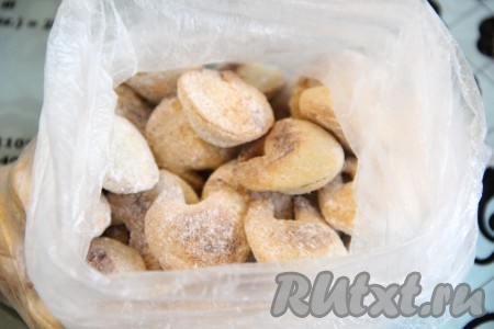 Готовое печенье слегка остудить, затем переложить в пакет и добавить пару столовых ложек сахарной пудры. Завязать пакет и хорошо его потрясти, чтобы печеньки полностью покрылись пудрой.
