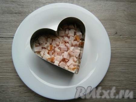 Копченую курицу (филе, окорочок) нарезать небольшими кусочками и выложить вторым слоем, чуть смазать майонезом.
