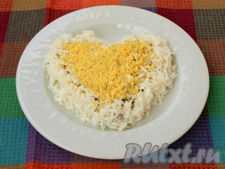 Желтки натереть на мелкой тёрке и выложить в центре сердца (как на фото), можно присолить.
