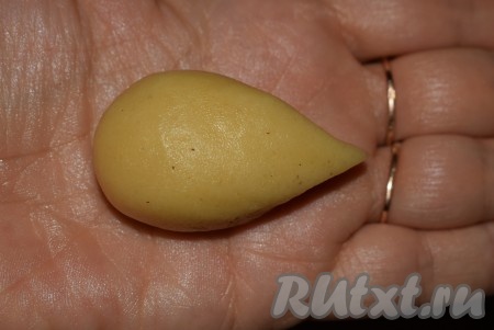 Далее из шарика формируем удлиненную заготовку в форме ёжика, как на фото. Аналогично из всех кусочков теста формируем "ёжиков".
