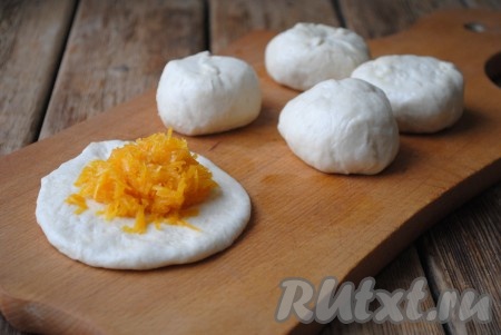 На столе, припыленном мукой, раскатать каждый шарик в лепёшку, в центр выложить 1 столовую ложку остывшей тыквенной начинки.
