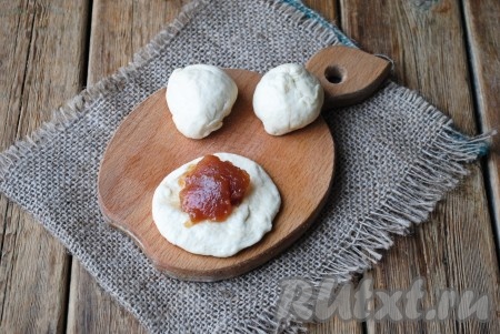 Каждый кусочек теста тонко раскатать, выложить в центр теста варенье и защипать края, формируя пирожок.