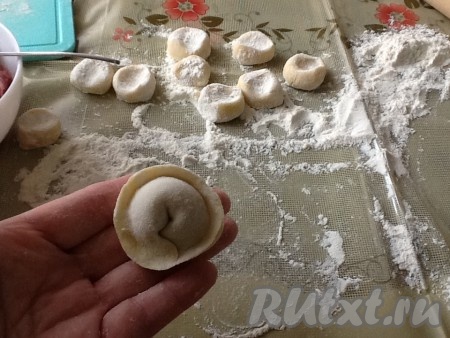 На раскатанный кружок кладём ложечку фарша и аккуратно лепим пельмешек.