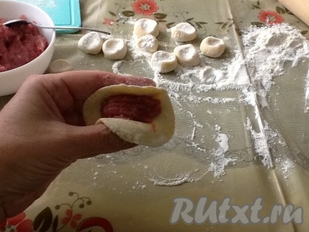 На раскатанный кружок кладём ложечку фарша и аккуратно лепим пельмешек.