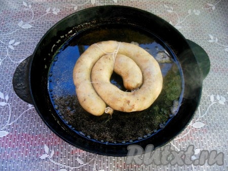 Разогрейте сковороду со смальцем (или с растительным маслом), выложите колечко домашней колбасы из курицы и свинины.